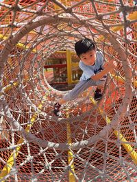 Full length of  children standing on chainlink fence