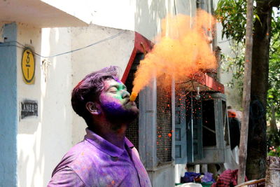 Man standing against multi colored wall