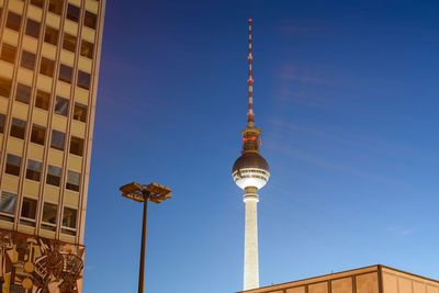 Low angle view of communications tower against blue sky