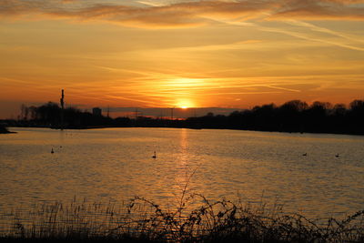 Scenic view of lake against romantic sky at sunset