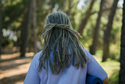 Rear view of woman standing in forest