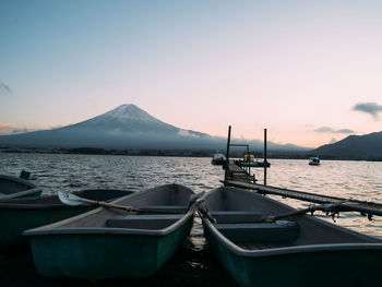 Boats moored in sea against clear sky