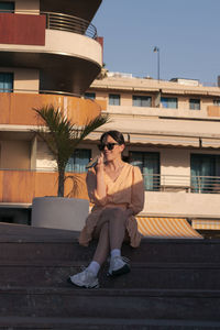 Full length of woman sitting outdoors