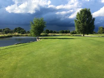 Scenic view of golf course against sky