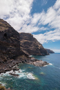 Scenic view of sea and mountains against sky