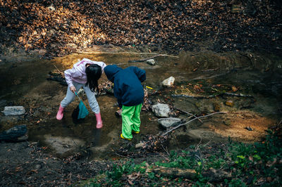 Asian boy and girl in the forest. two asian children fishing with a net to discover nature. 