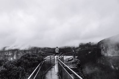 Rear view of man standing at observation point in blue mountains national park during foggy weather