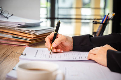 Midsection of man holding paper at table