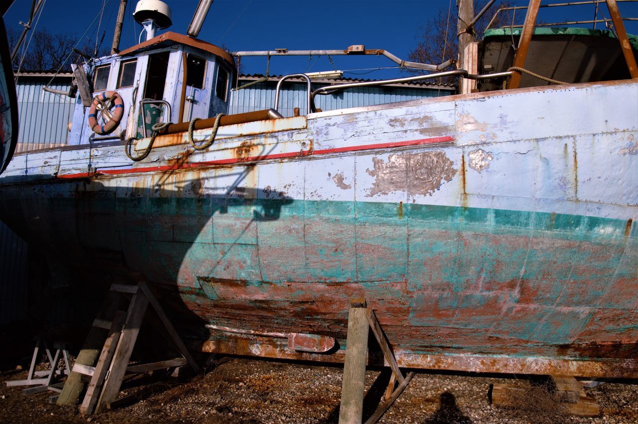 ABANDONED BOATS MOORED ON RUSTY SHIP