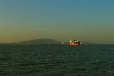 Ship sailing in sea against clear sky