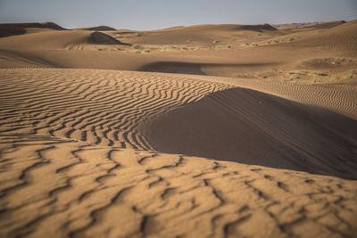 Sand dune in desert against sky