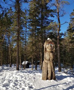 Statue amidst trees in forest during winter