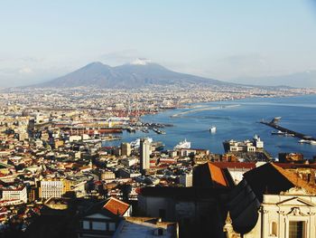 High angle view of townscape by sea against sky