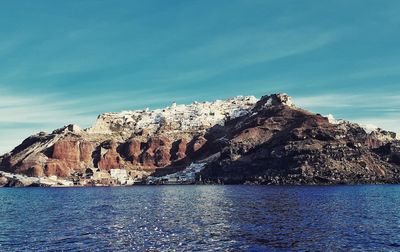 Scenic view of sea and rocks against blue sky. oia, santorini 