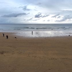 Scenic view of beach against cloudy sky