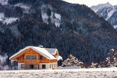 Modern mountain house with snowcapped mountains in background in ski region austria