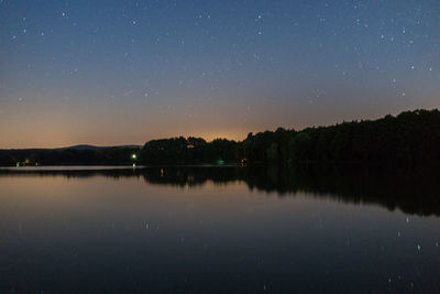 Scenic view of lake against clear sky at night