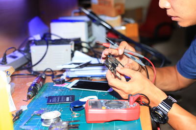 Close-up of man working on circuit board by table