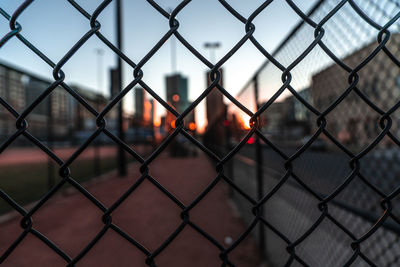 Full frame shot of chainlink fence against sky during sunset