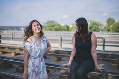 Woman smiling while standing against railing