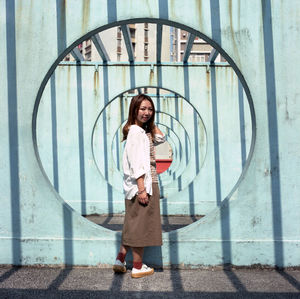 Portrait of woman standing against wall