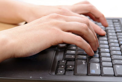 Cropped hands of person using laptop