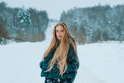 Young woman standing on snow covered field