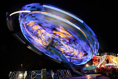 Low angle view of illuminated ferris wheel against sky at night