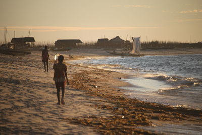 Silhouette people walking at beach