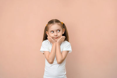 Portrait of young woman standing against wall