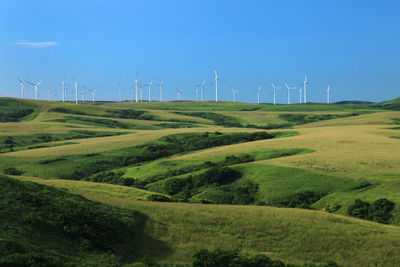 Windmills of landscape against blue sky