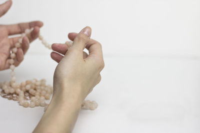 Close-up of hand holding hands over white background