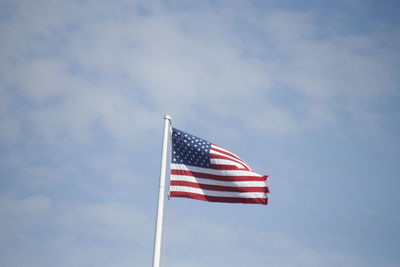 Low angle view of flag against blue sky