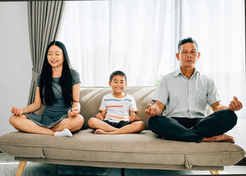 Portrait of family sitting on sofa at home