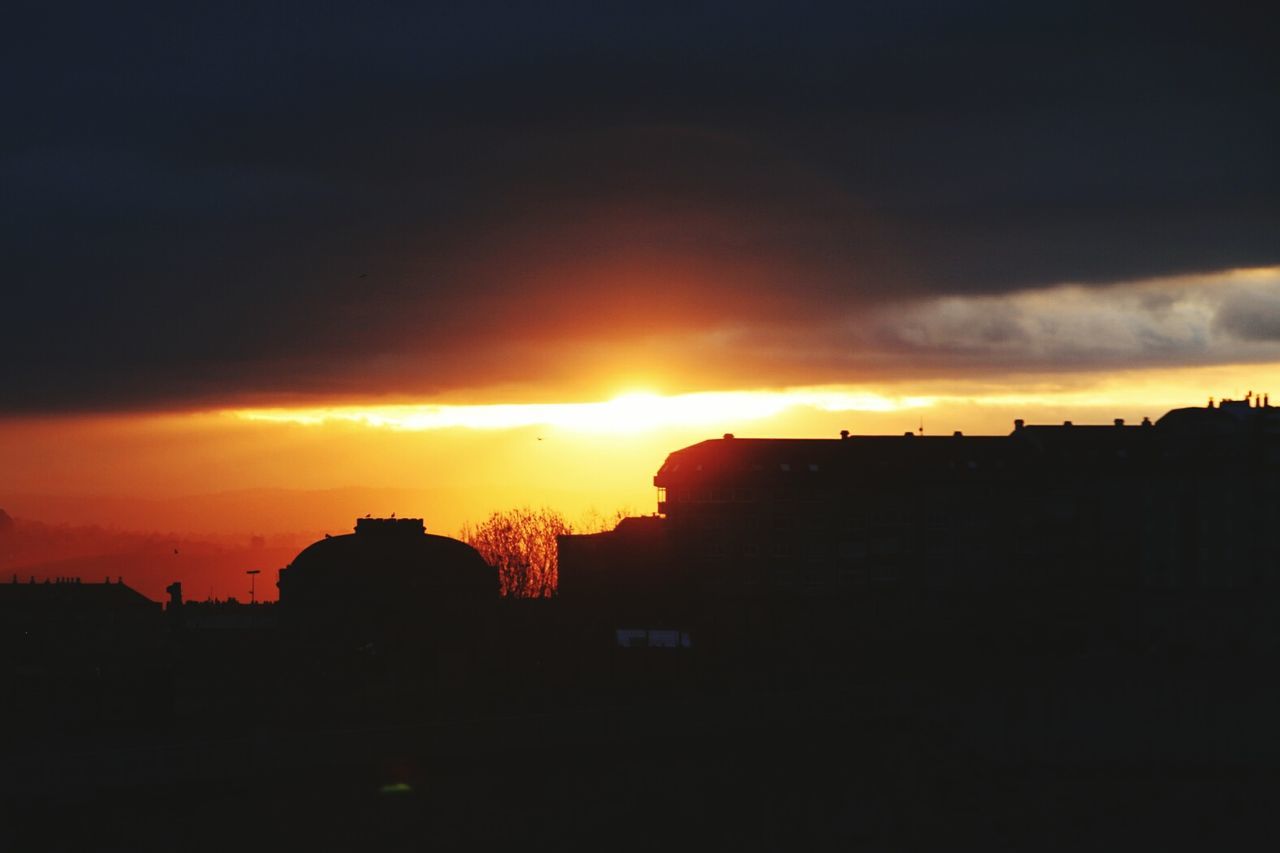 sunset, silhouette, orange color, sky, building exterior, sun, architecture, built structure, scenics, cloud - sky, beauty in nature, dramatic sky, idyllic, nature, cloud, tranquil scene, dark, tranquility, sunlight, moody sky