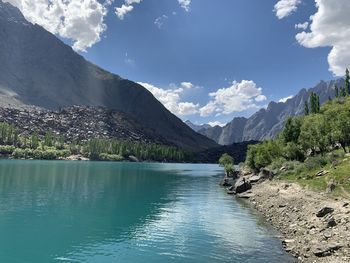 Scenic view of lake by mountains against sky