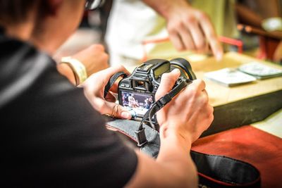 Close-up of hands holding digital camera