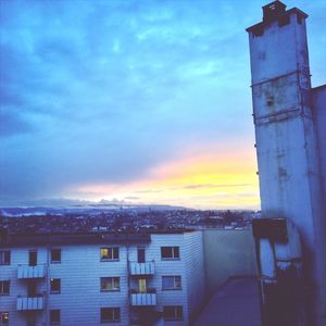 Buildings against cloudy sky at sunset