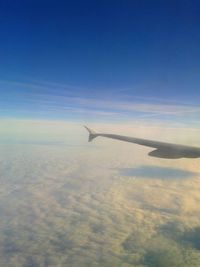 Cropped image of airplane flying over cloudscape