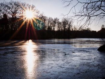 Sun shining over lake during winter