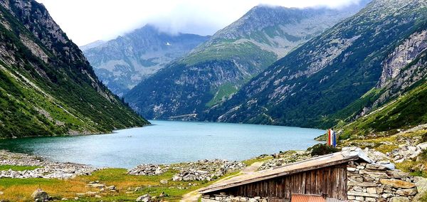 Scenic view of lake by mountains against sky