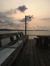 Pier on sea against cloudy sky