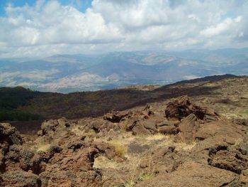 Scenic view of mountains against cloudy sky