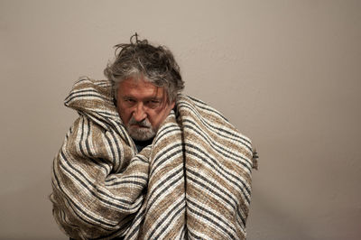 Portrait of man standing against wall