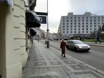 Vehicles on road by buildings in city