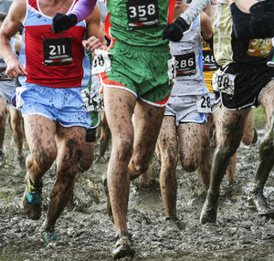 Low section of people running on mud