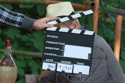 Cinematographic set, clapperboard in the foreground, actor with hat in the background.