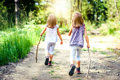 Rear view of girls walking on road