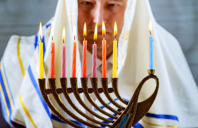 Close-up of priest looking at lit candles