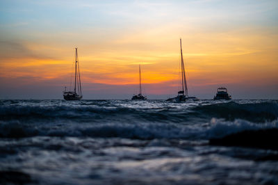 Sailboat sailing on sea against romantic sky at sunset